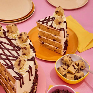 Cookie Dough Cake with four chocolate chip sponge layers, vanilla buttercream, chocolate ganache drip, and edible cookie dough chunks.